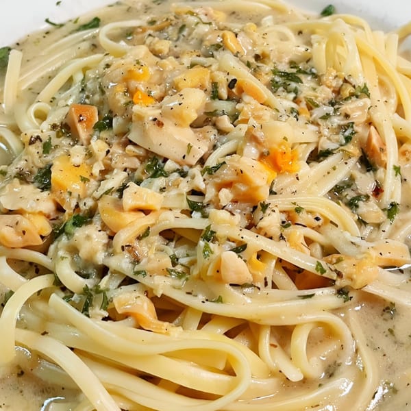 Close-up of Genova's Italian Restaurant's linguine with clams in a creamy white sauce, garnished with parsley.